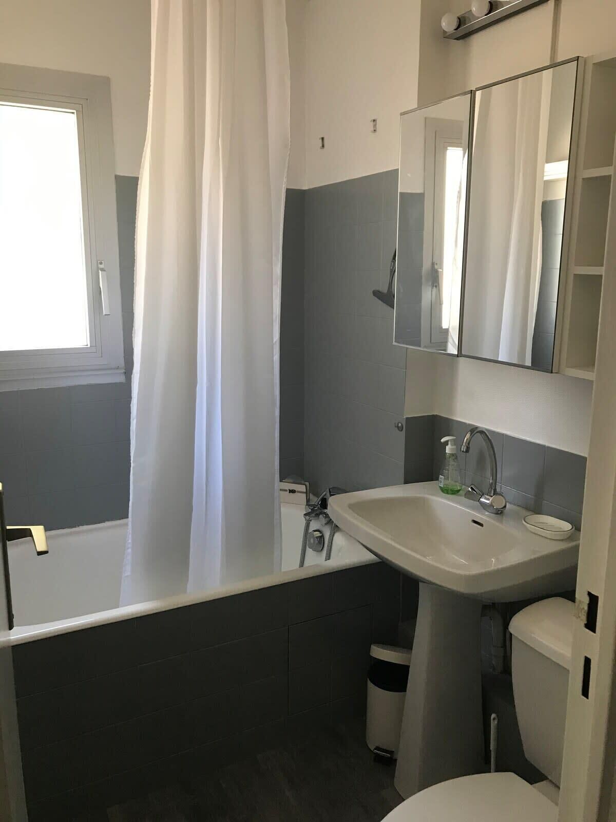 A bathroom with a bathtub, a sink, a toilet, and a mirror.