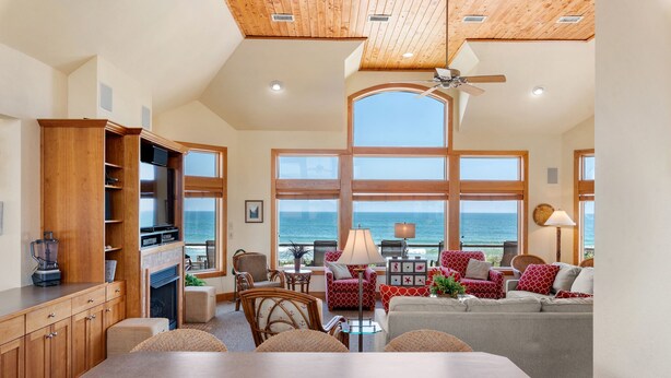 A spacious living area with a large dining table, comfortable seating, and a view of the ocean. - Dutch Treat: Oceanfront | Private Pool | Elevator (Corolla)