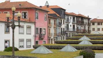 A row of colorful buildings with terracotta roofs and a street lamp in the foreground.