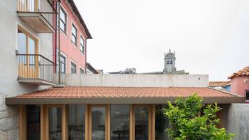 Un edificio con tetto in tegole rosse, ampie finestre e un balcone.