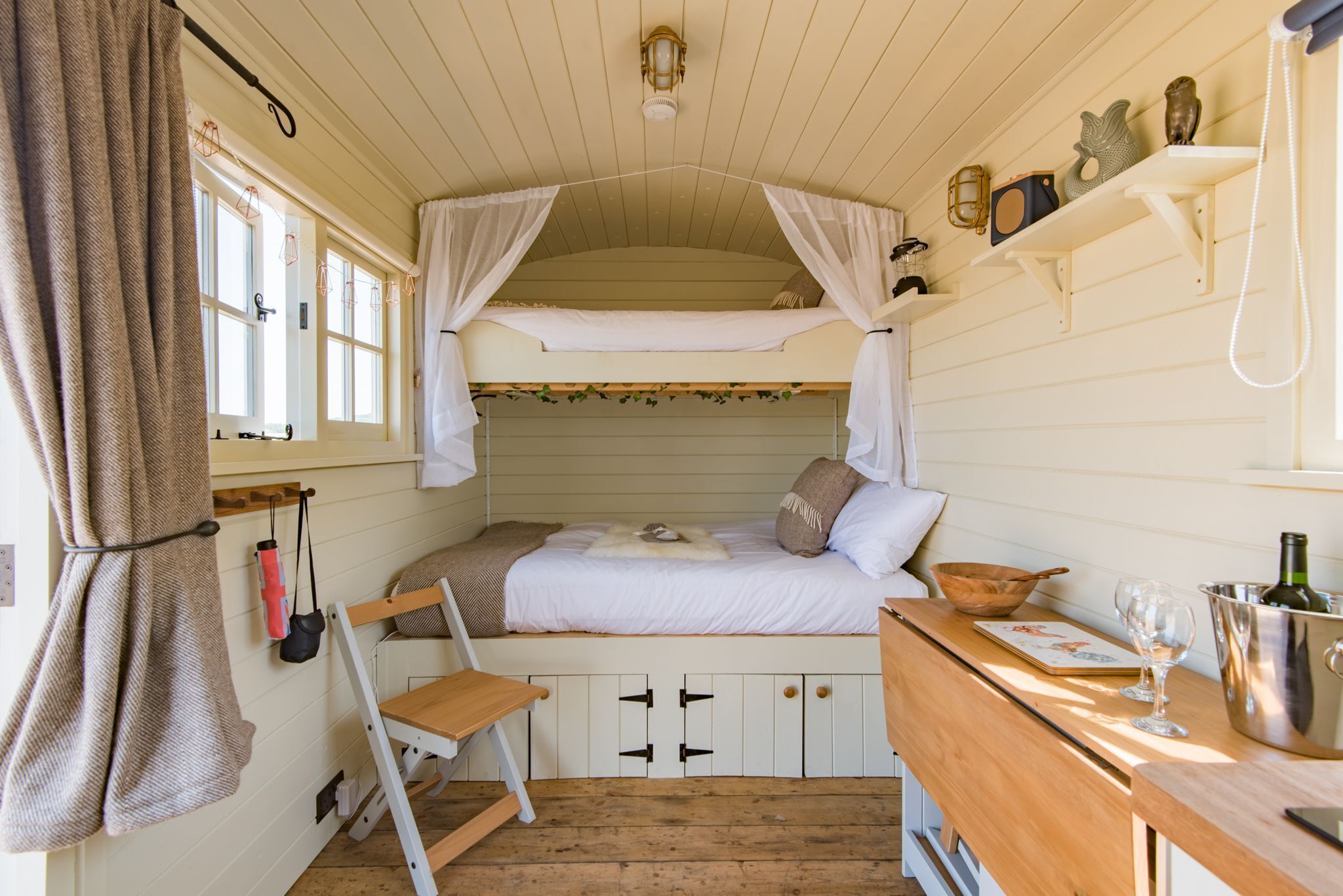 Une pièce chaleureuse et bien éclairée, avec un lit superposé, un bureau en bois et un petit coin salon.
