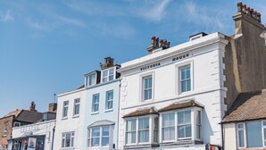 Una hilera de edificios tradicionales con letreros que indican 'The Stag' y 'Victoria House'.