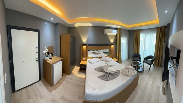 Een moderne hotelkamer met een groot bed, nachtkastjes, een bureau, een kledingkast en een televisie.
