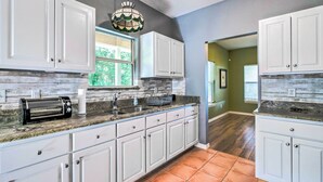 A kitchen with white cabinets, a toaster, and a hanging light fixture. - Lovely Hawthorne Home w/ Private Boat Dock! (Hawthorne)
