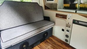 Una cocina compacta con microondas, un lavamanos y una zona de estar con bancos.