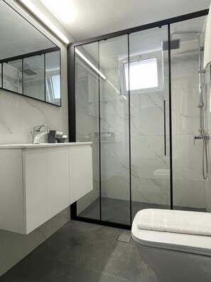 Deluxe kamer | Badkamer | Een douche, een regendouche, een haardroger, pantoffels