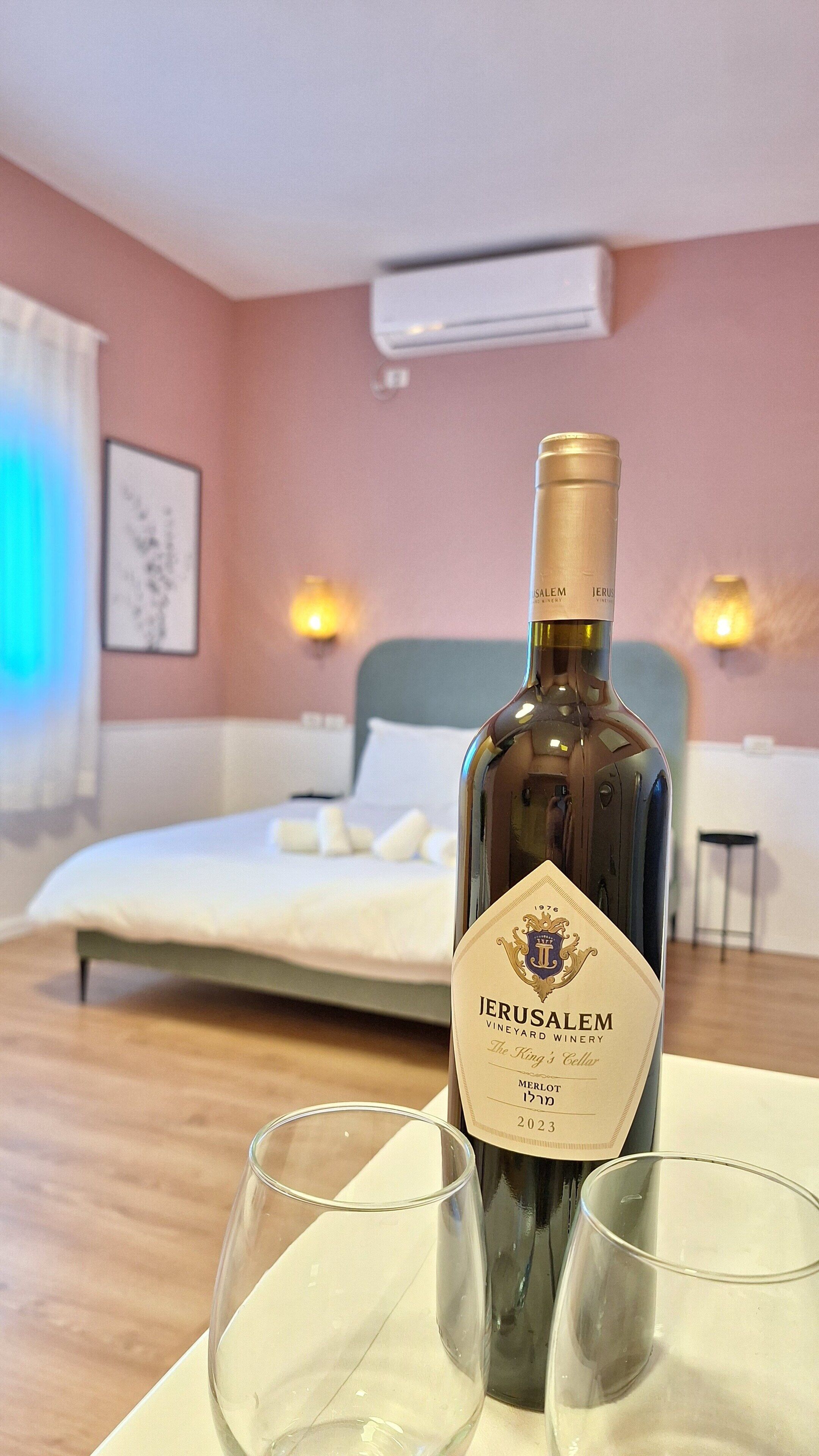 Eine Flasche Jerusalem Vineyard Wein mit zwei leeren Gläsern in einem Hotelzimmer.