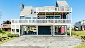 A two-story house with a covered front porch, a garage, and a small garden area.