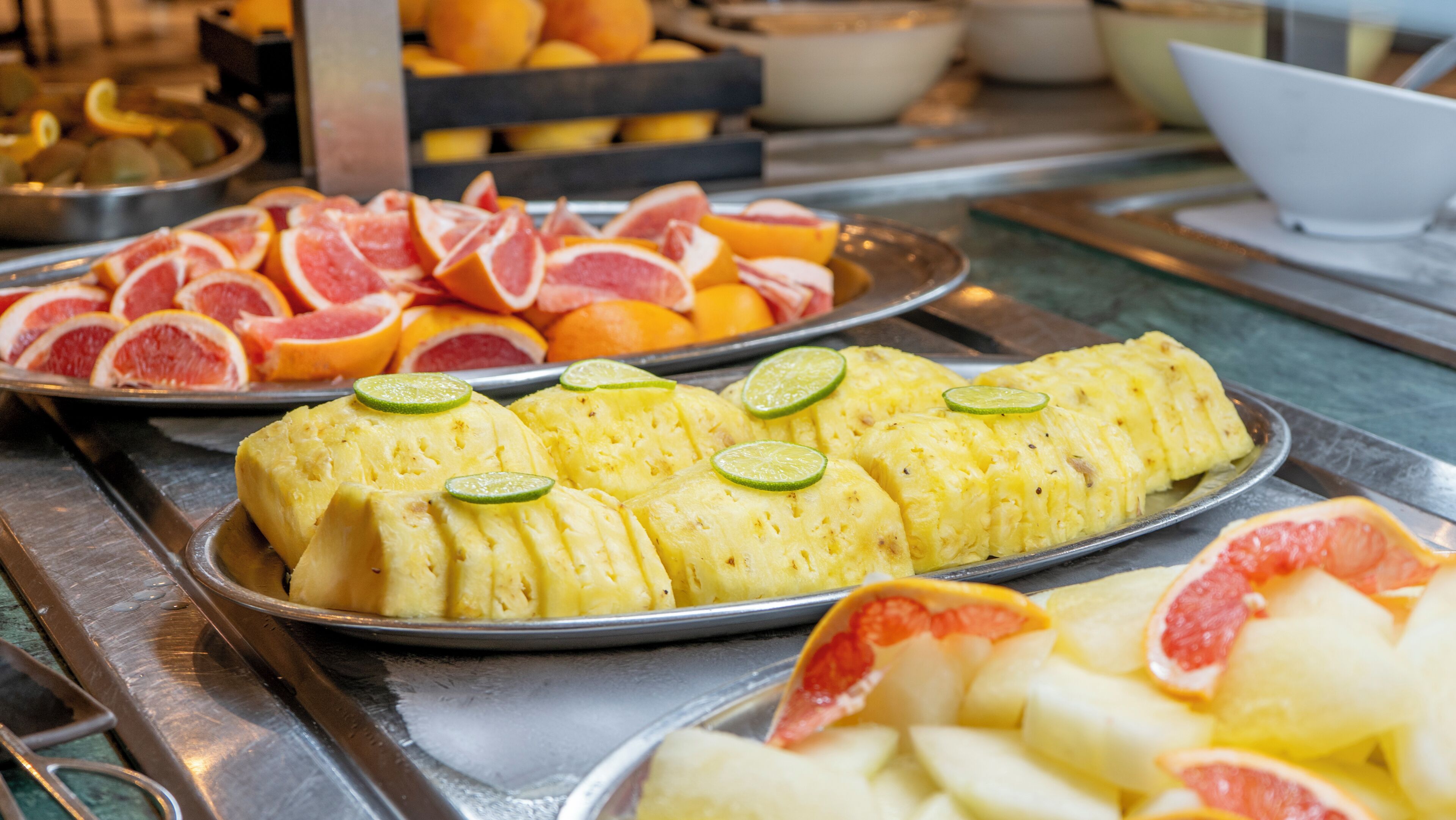 A buffet with various fruits and a pineapple dish.