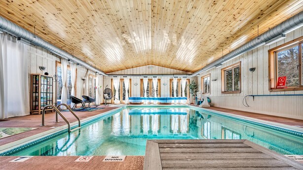 An indoor swimming pool with wooden walls and ceiling, clear signage indicating no diving, and a poolside area with chairs and a sun lounger. - INDOOR POOL, HOT TUB, PRIVATE 86 acre Retreat and Event Space (Hanover)