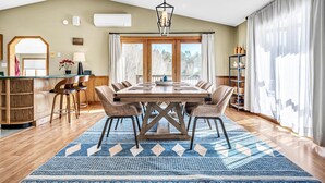 A dining area with a large wooden table, six chairs, and a blue patterned rug. - INDOOR POOL, HOT TUB, PRIVATE 86 acre Retreat and Event Space (Hanover)