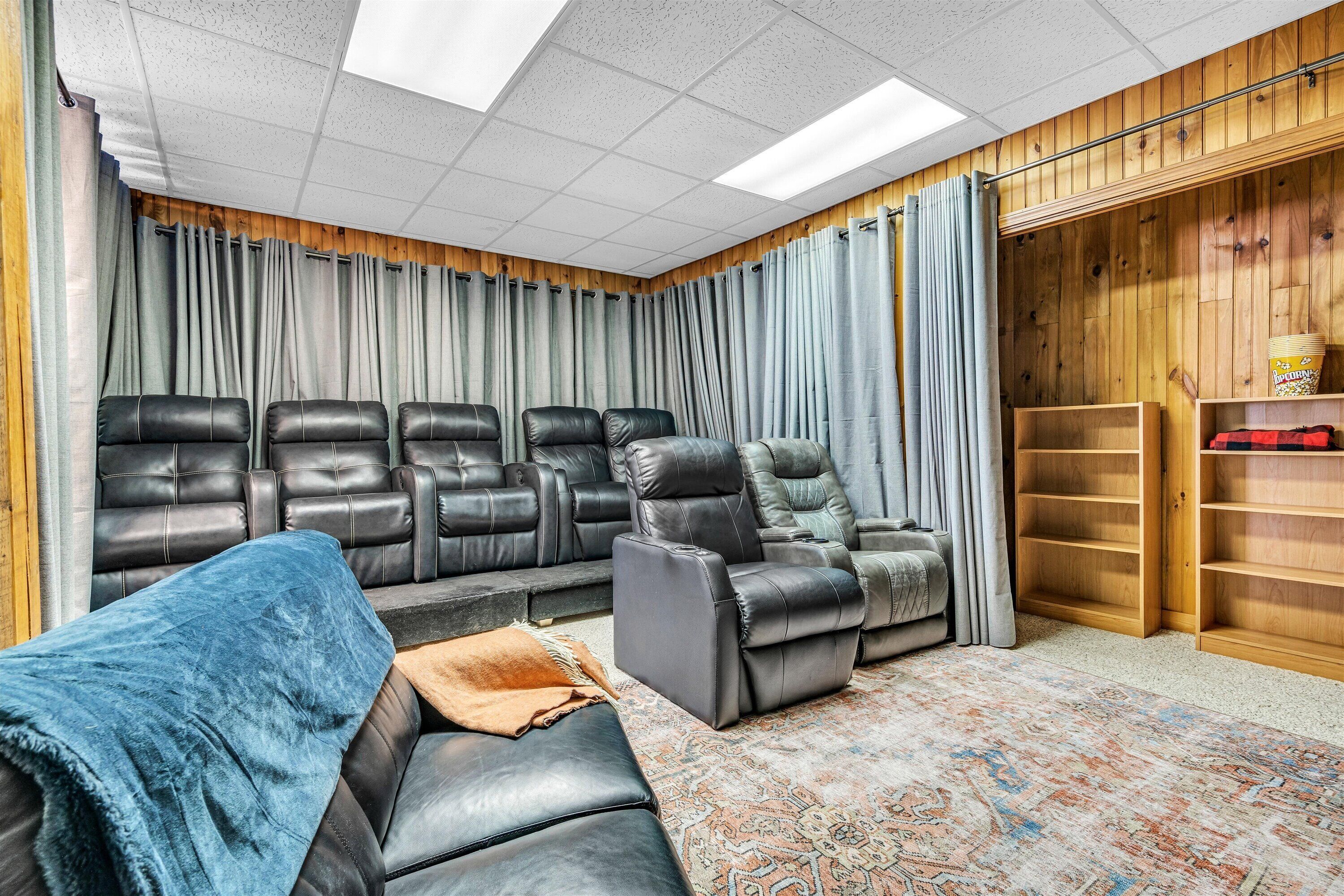 Una habitación con un sofá modular, un sillón reclinable y una alfombra estampada.