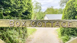 A wooden sign with the words "Box Cottage" indicating the entrance to a property. - Bluebell Cottage (Tavistock)