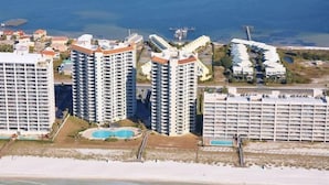 A coastal area with high-rise buildings, a beach, and a swimming pool.