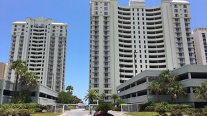A high-rise residential building with multiple balconies and a gated entrance.