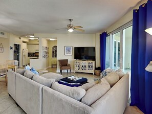 Una sala de estar con un sofá, televisión y un comedor con mesa y sillas.