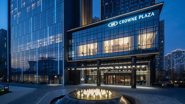 Un bâtiment moderne avec une façade en verre et une enseigne indiquant « CROWNE PLAZA ».