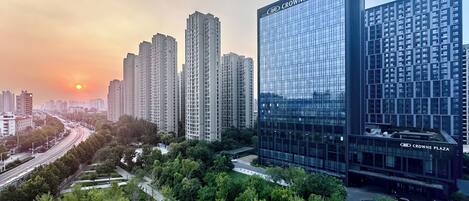 A modern high-rise building with a glass facade and the name "CROWNE PLAZA" on the top.
