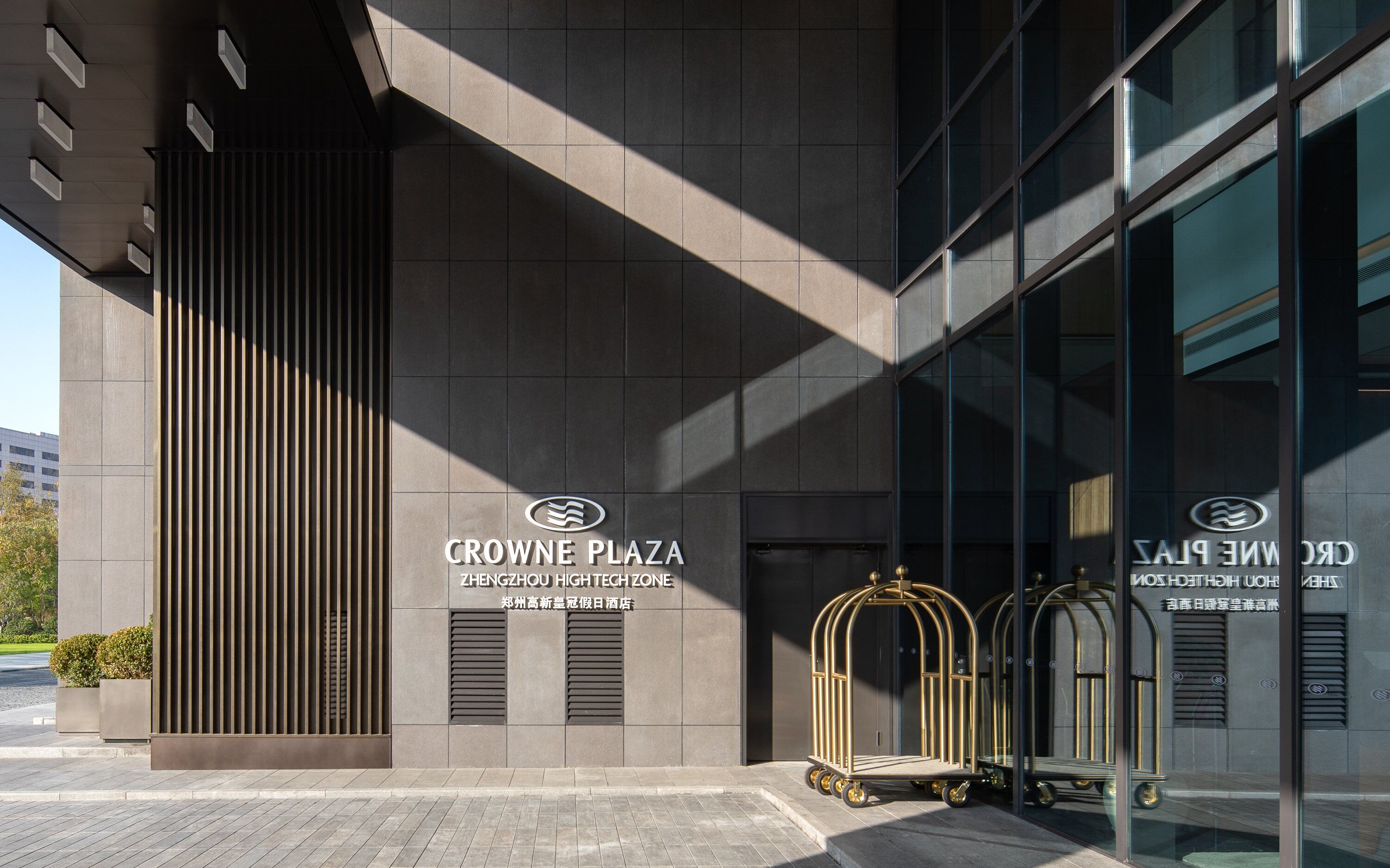 Een moderne gevel met de aanduiding "CROWNE PLAZA ZHENGZHOU HIGH TECH ZONE".