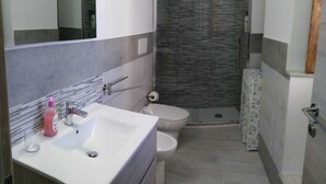A modern bathroom with a shower, toilet, and sink. - Two-roomed house "In centro" + services in the baroque heart of the city (Noto)