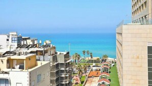 A coastal cityscape with a view of the sea, modern buildings, and a clear sky. - O&O Group - Deluxe Beachfront 3 BR Penthouse (Bat Yam)