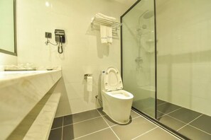Un bagno moderno con cabina doccia in vetro, un water bianco e un lavabo in marmo.