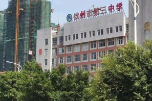 A building with multiple floors and a sign indicating it is a school.