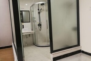Un bagno moderno con doccia vetrata, lavandino e specchio.