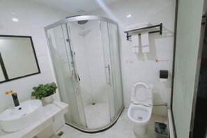 Un bagno moderno con doccia vetro, lavandino bianco e water.