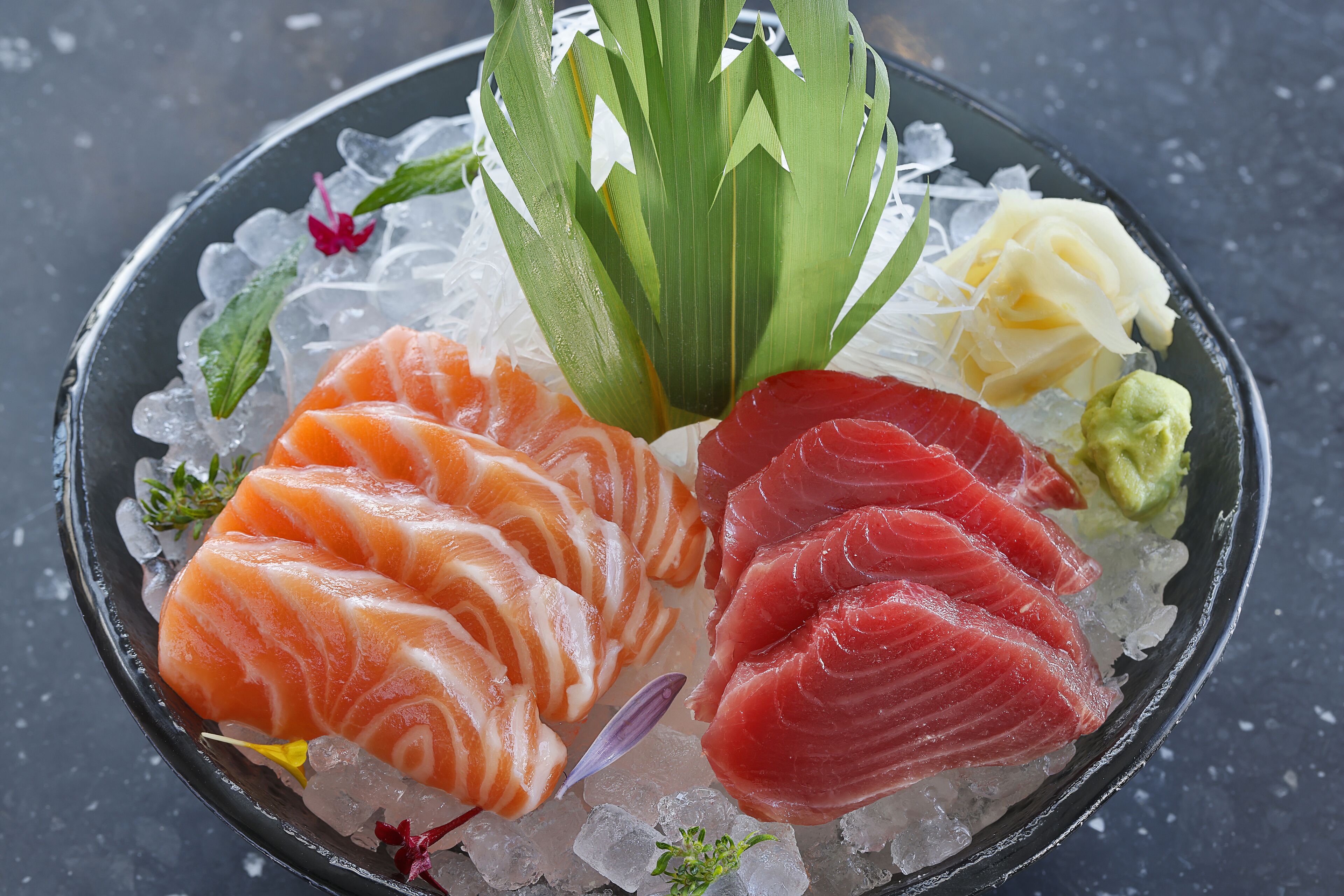 A plate of sushi with various types of fish and garnishes.