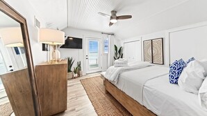 A bedroom with a bed, a ceiling fan, a TV, and a door with blinds. - Lux Beachfront House*Private*Fully Loaded*Firepit (Gulf Shores)