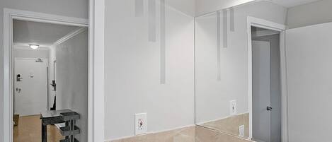 A bathroom with a white sink, a mirror, and a light fixture above it. There is a bottle of hand soap on the counter.
