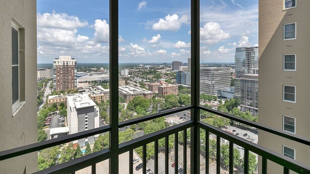 A high-rise building with multiple floors, large windows, and a view of a cityscape with various buildings and streets. - 21 first floor cozy condo in the center of DT Atlanta (Atlanta)