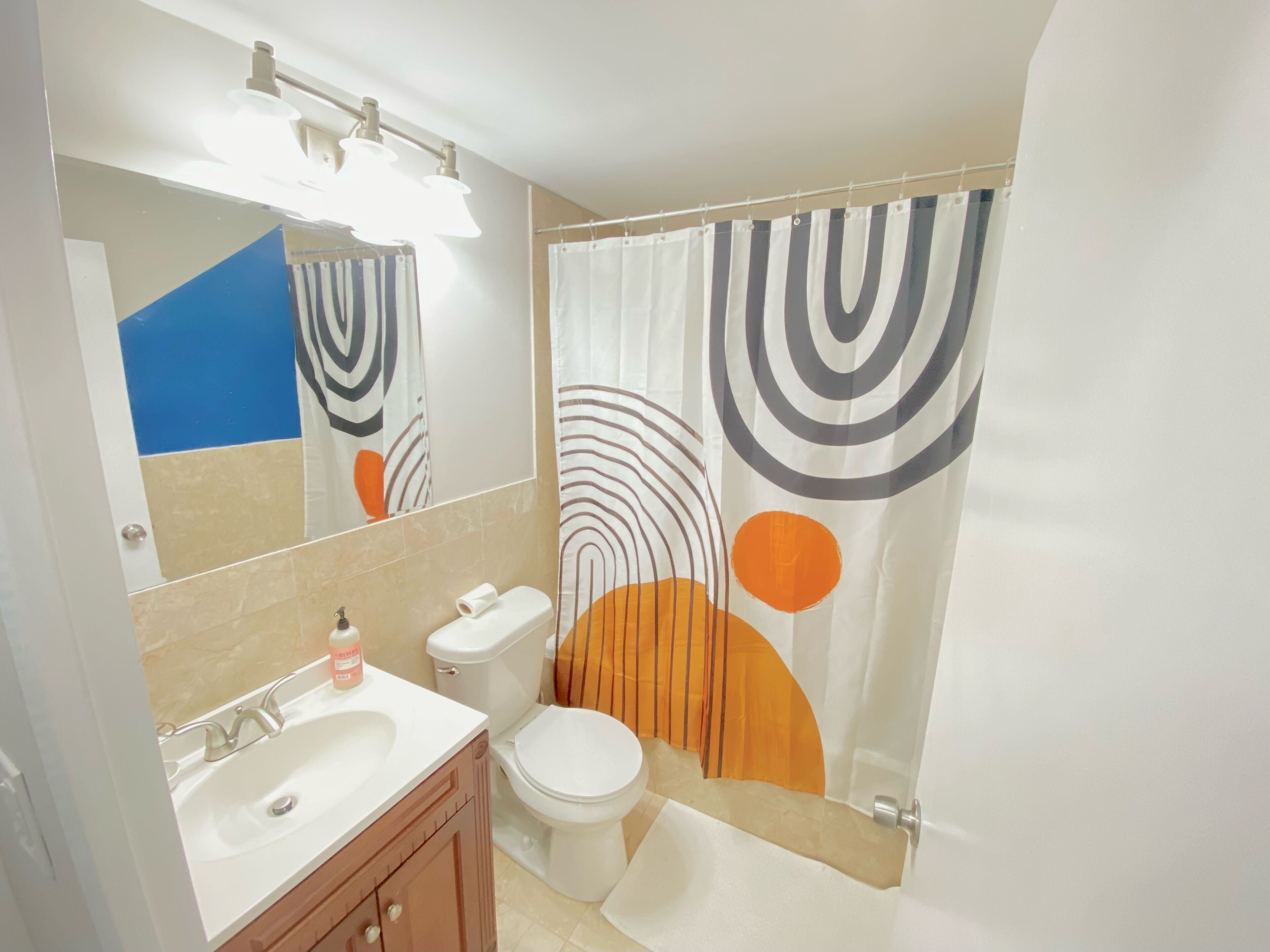 Un baño con lavabo, inodoro y cortina de ducha.