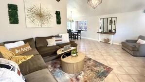 A spacious living room with a brown sofa, a coffee table, and a dining area in the background. - 3 Bdr/2 Bth home between Katy and Houston close to HWY 10 and Green house  (Katy)