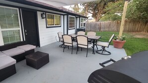 A covered patio with a dining table and chairs, a sofa, and a trash can. - 3 Bdr/2 Bth home between Katy and Houston close to HWY 10 and Green house  (Katy)