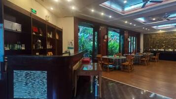 A hotel lobby with a reception desk, seating area, and large windows.