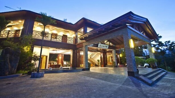 A modern hotel with a spacious entrance, a covered outdoor area, and a well-lit facade.