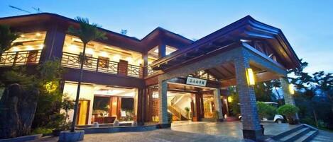 A multi-story hotel with a covered entrance and a well-lit facade.