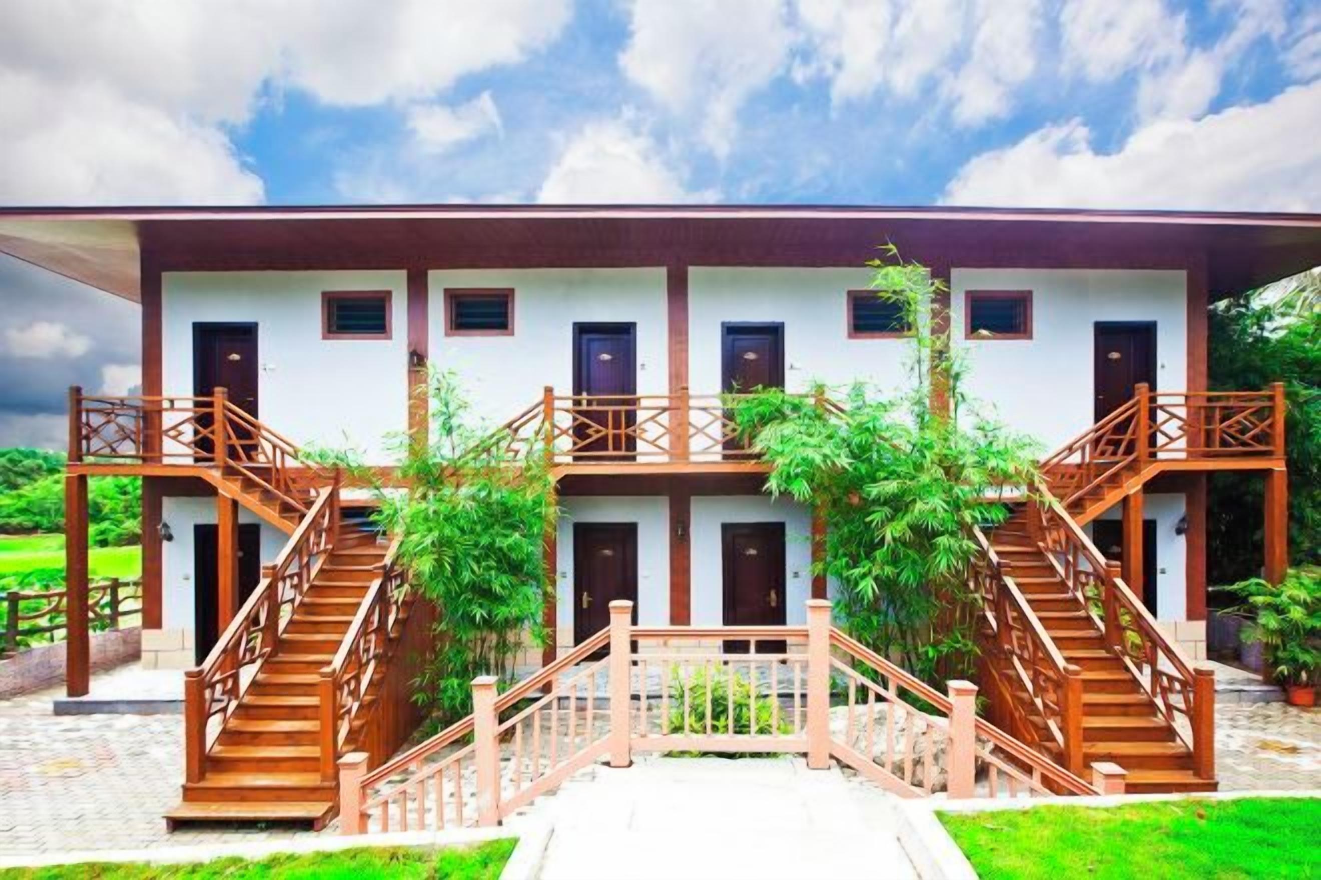 A two-story building with a central staircase and a balcony on each floor.