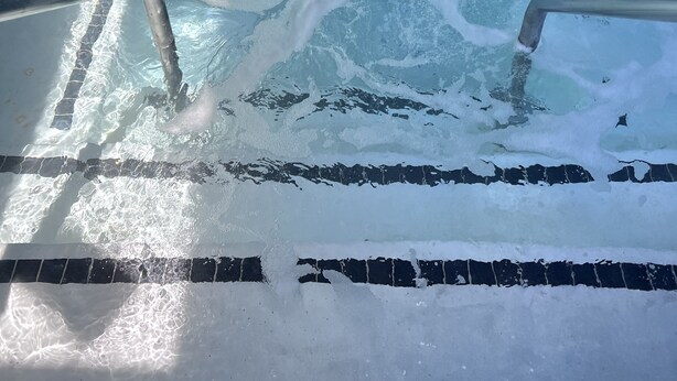 A rectangular swimming pool with clear water, marked lanes, and a metal ladder. - 2 Room Suite - Indoor Pool and Spa - Walk to the Boardwalk (Santa Cruz)
