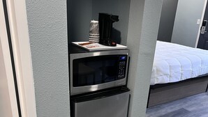 A compact kitchenette with a stainless steel microwave and oven, a coffee maker, and a small countertop. - 2 Room Suite - Indoor Pool and Spa - Walk to the Boardwalk (Santa Cruz)
