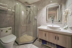 A modern bathroom with a glass-enclosed shower, a toilet, a sink with a mirror, and a hairdryer on the wall. - Yuedu Yizhan Fashion Hotel (Yichun)