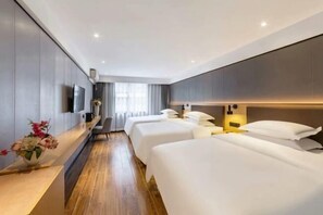 A hotel room with two beds, a TV, a desk with a vase of flowers, and a window with curtains. - Yuedu Yizhan Fashion Hotel (Yichun)
