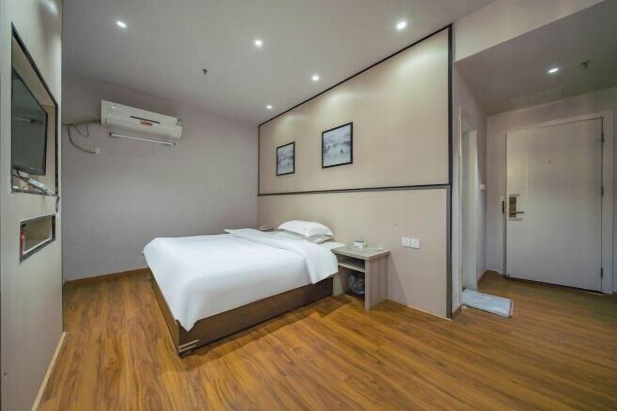 Un dormitorio con cama, mesita de noche y aire acondicionado instalado en la pared.