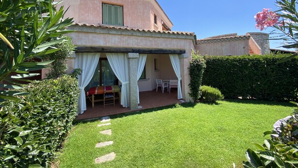 Una casa con patio, una mesa pequeña y sillas.