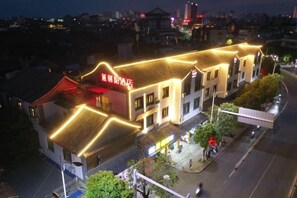 A traditional building with a red sign, multiple windows, and a street in front. - Yanchaoyang Boutique Inn (Jianshui)