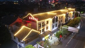 A hotel with a traditional architectural style, featuring a red awning and illuminated signage. - Yanchaoyang Boutique Inn (Jianshui)