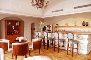 Un comedor con barra, sillas de madera y una estantería.