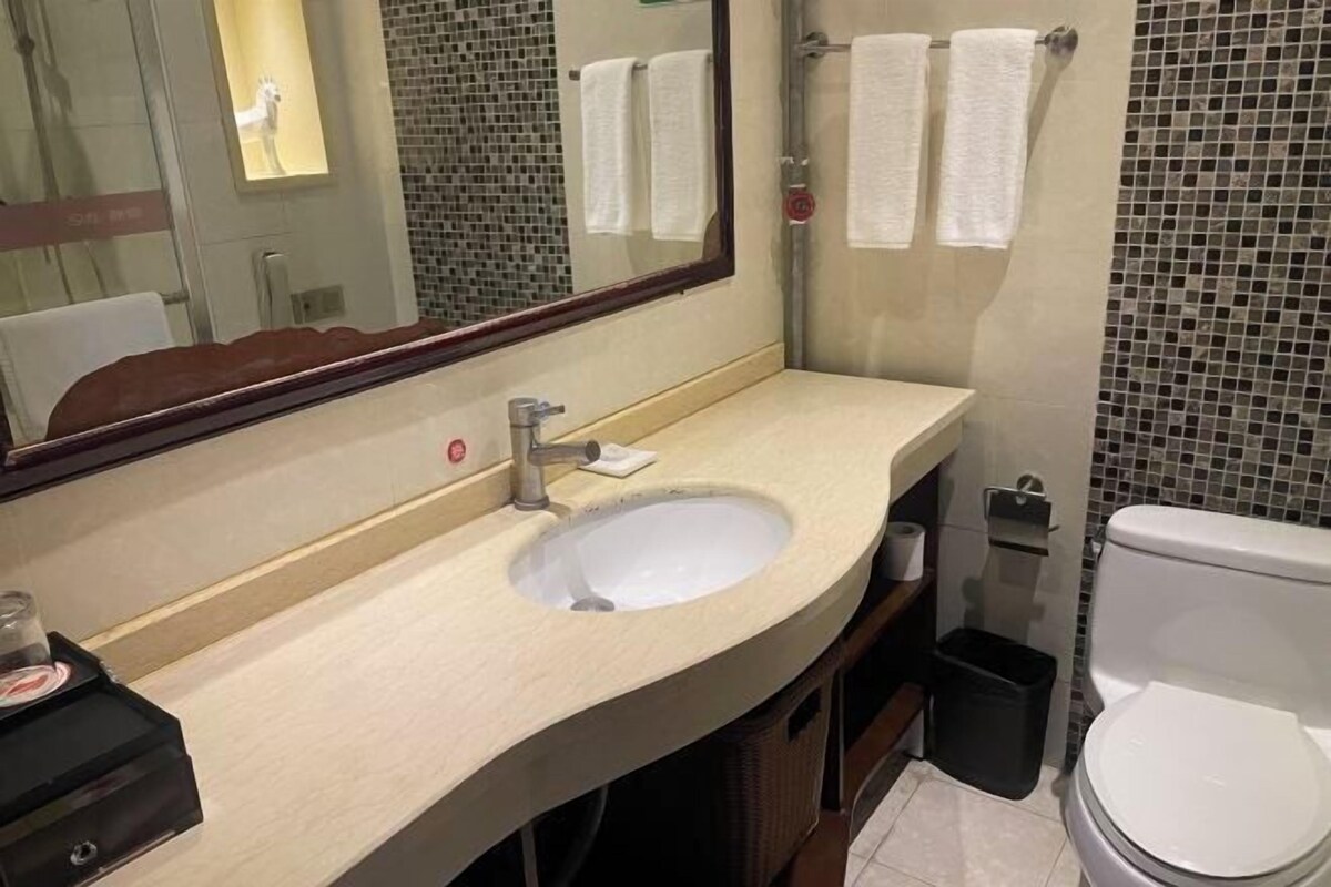 A bathroom with a sink, mirror, and toilet.